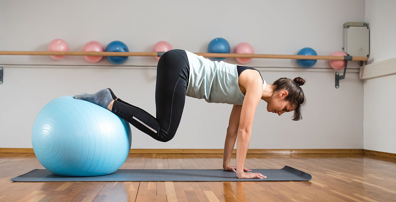 Using a Swiss ball for plank crunches