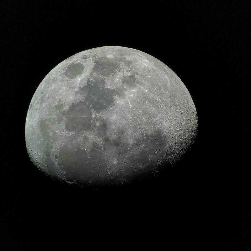 Waxing gibbous moon captured with a telescope and smartphone.